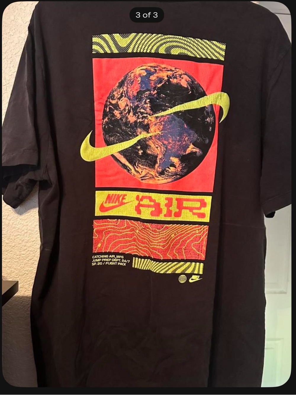 Men’s Nike Black Tee with Neon Duo Colored Nike Signs & Globe Graphic on back.